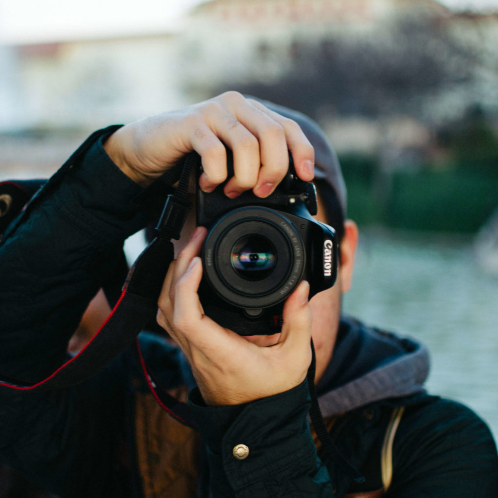 A Discipleship Training School Photography and Storytelling track student, taking a photo with a Canon camera