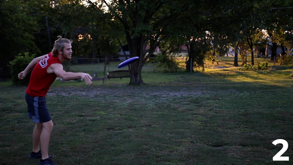 A student, Trenton, throwing a frisbee